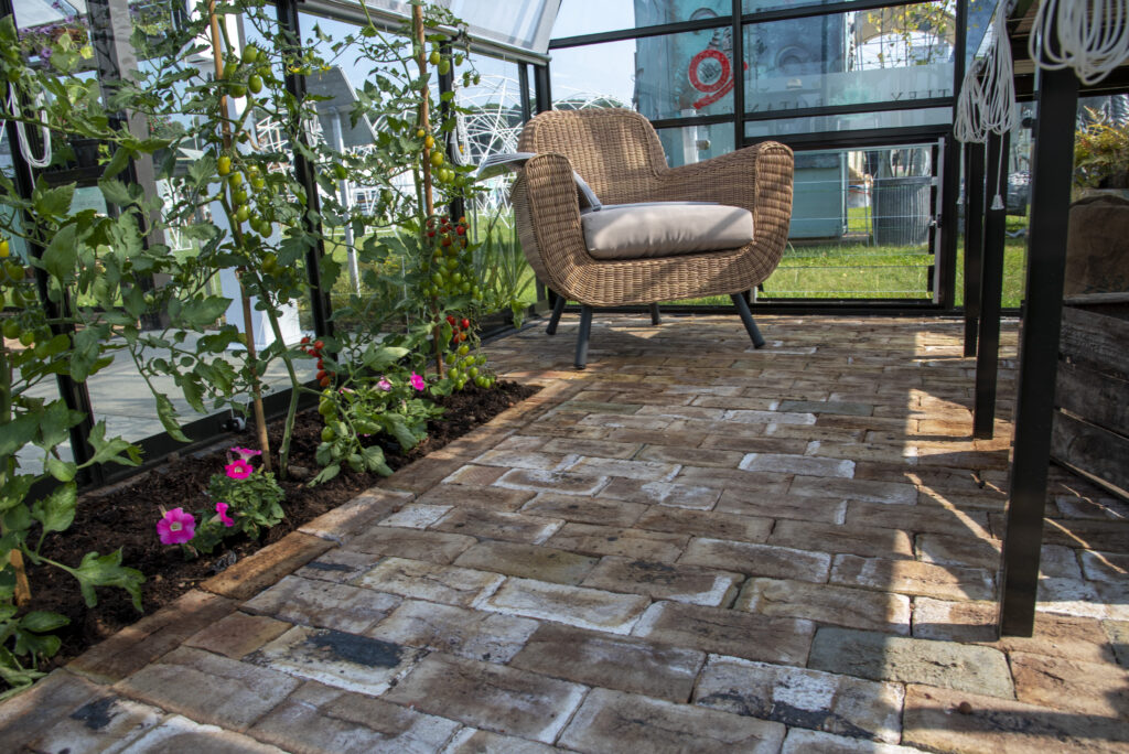 London Mixture Clay Pavers are paired with tomato plant in the flower beds and a wicker chair to create a traditional feel. 