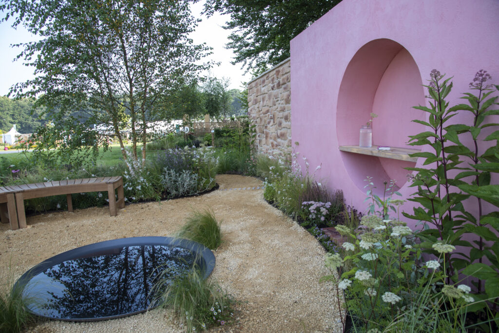 The Dreamscape Garden has a pink feature wall, circular water feature and curved benches. Our Seville Clay Pavers sit at the base of the wall to add the finishing touches. 